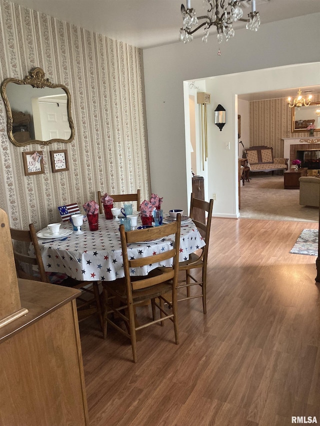 301 N Louise St, La Harpe, IL 61450 - dining space featuring a chandelier, wallpapered walls, and wood finished floors