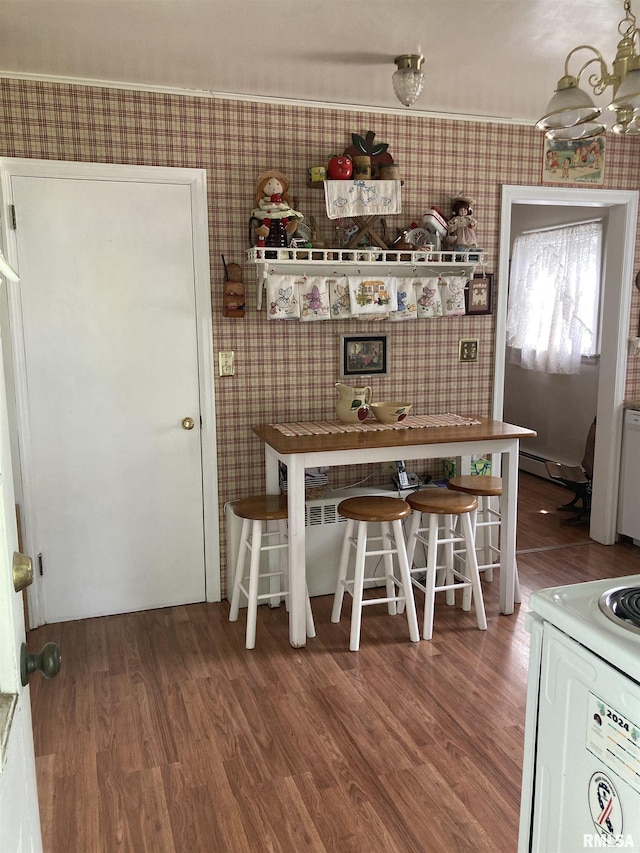 301 N Louise St, La Harpe, IL 61450 - dining room with wallpapered walls, wood finished floors, and baseboard heating