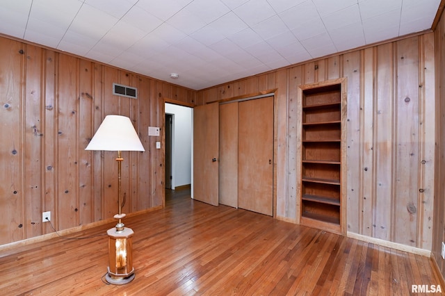 113 Highview Ter, East Peoria, IL 61611 - unfurnished bedroom featuring wooden walls, hardwood / wood-style floors, and a closet