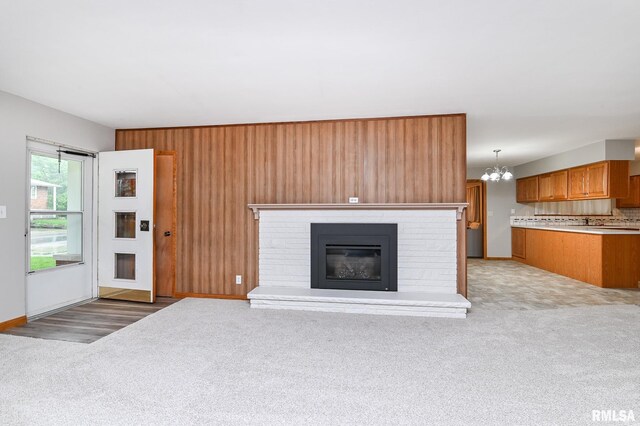 113 Highview Ter, East Peoria, IL 61611 - unfurnished living room with light colored carpet, a chandelier, a fireplace, and wooden walls