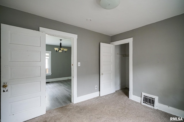 409 E Embert Pl, Peoria, IL 61603 - unfurnished bedroom featuring a chandelier, carpet flooring, and a closet