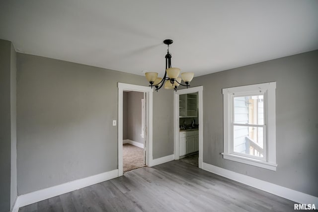 409 E Embert Pl, Peoria, IL 61603 - unfurnished dining area featuring a chandelier and wood finished floors