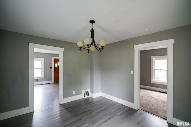 409 E Embert Pl, Peoria, IL 61603 - spare room featuring a chandelier and dark wood-style flooring