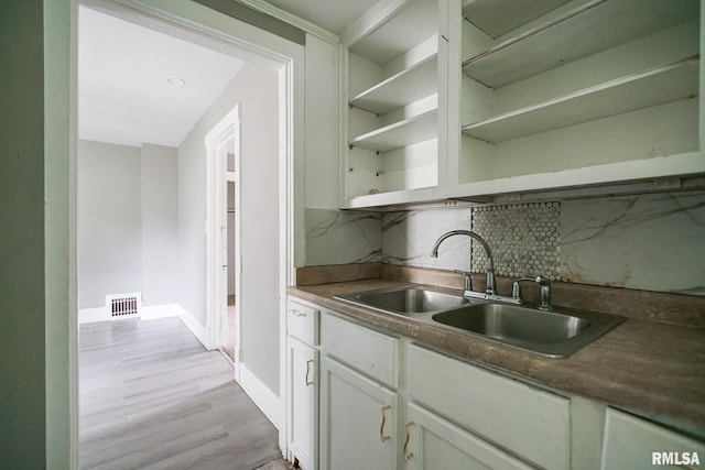 409 E Embert Pl, Peoria, IL 61603 - kitchen with open shelves, backsplash, white cabinets, and light wood-style floors