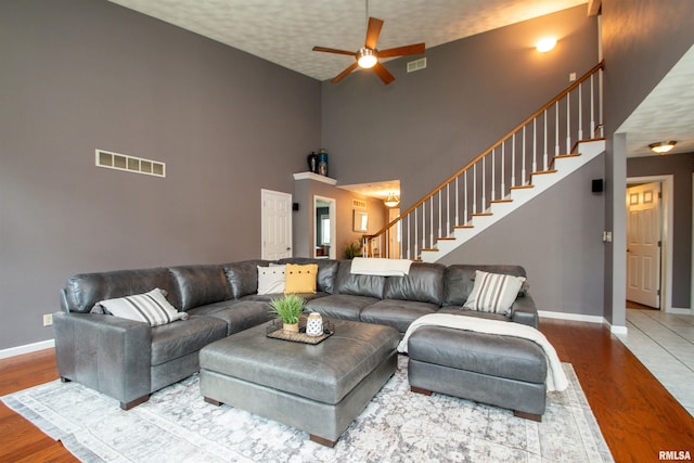 116 Field Ct, East Peoria, IL 61611 - living room featuring stairway, wood finished floors, ceiling fan, and a high ceiling