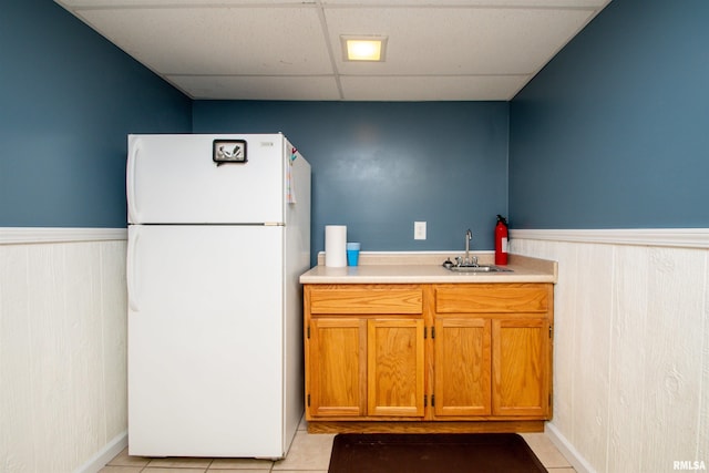 116 Field Ct, East Peoria, IL 61611 - kitchen with freestanding refrigerator, a paneled ceiling, brown cabinetry, wainscoting, and light countertops
