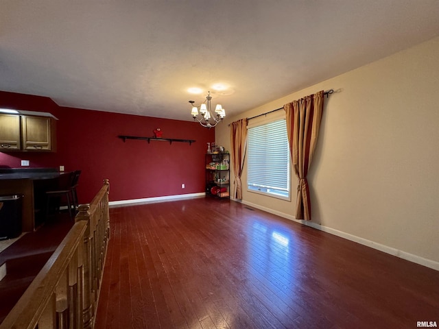 15 Elmo Dr, Macomb, IL 61455 - unfurnished living room with dark wood-type flooring and a chandelier