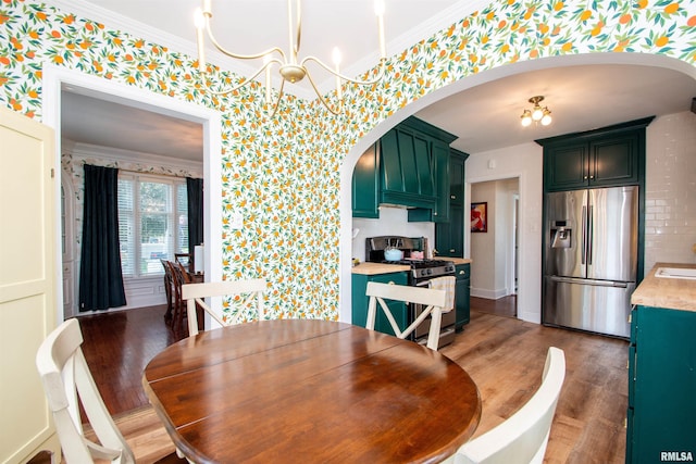 3316 N Biltmore Ave, Peoria, IL 61604 - dining room with wallpapered walls, arched walkways, wood finished floors, ornamental molding, and a chandelier