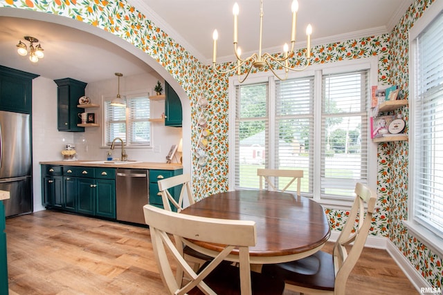 3316 N Biltmore Ave, Peoria, IL 61604 - dining room with wallpapered walls, a chandelier, crown molding, light wood-style floors, and plenty of natural light