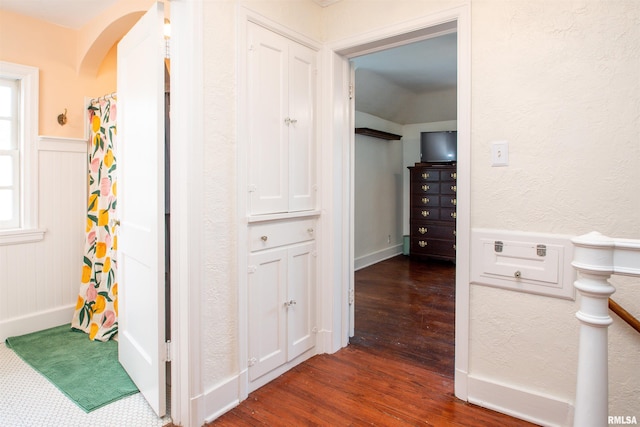 3316 N Biltmore Ave, Peoria, IL 61604 - hallway with dark wood finished floors, arched walkways, a wainscoted wall, a textured wall, and a decorative wall