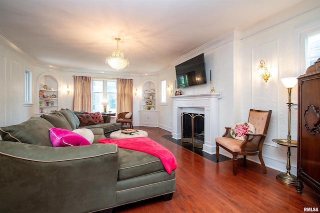 3316 N Biltmore Ave, Peoria, IL 61604 - living area featuring built in shelves, crown molding, wood finished floors, a chandelier, and a fireplace with flush hearth