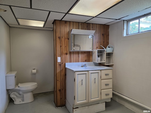 1507 W Circle Rd, Peoria, IL 61604 - half bath featuring concrete flooring, vanity, a drop ceiling, and wood walls