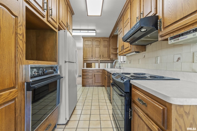 502 W Crestwood Dr, Peoria, IL 61614 - kitchen featuring under cabinet range hood, oven, electric range, freestanding refrigerator, and brown cabinetry