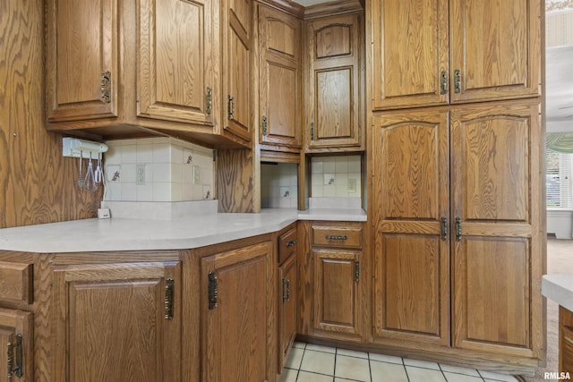 502 W Crestwood Dr, Peoria, IL 61614 - kitchen with brown cabinets, backsplash, and light countertops