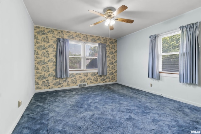 502 W Crestwood Dr, Peoria, IL 61614 - spare room featuring a ceiling fan, healthy amount of natural light, and dark colored carpet