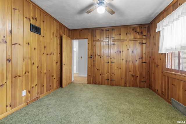 502 W Crestwood Dr, Peoria, IL 61614 - empty room featuring carpet flooring, wooden walls, and a ceiling fan