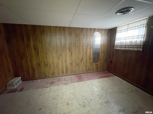 502 W Crestwood Dr, Peoria, IL 61614 - spare room with tile patterned floors, wooden walls, and a drop ceiling