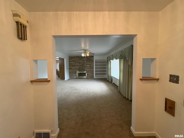 502 W Crestwood Dr, Peoria, IL 61614 - unfurnished living room featuring a ceiling fan, carpet flooring, and a stone fireplace
