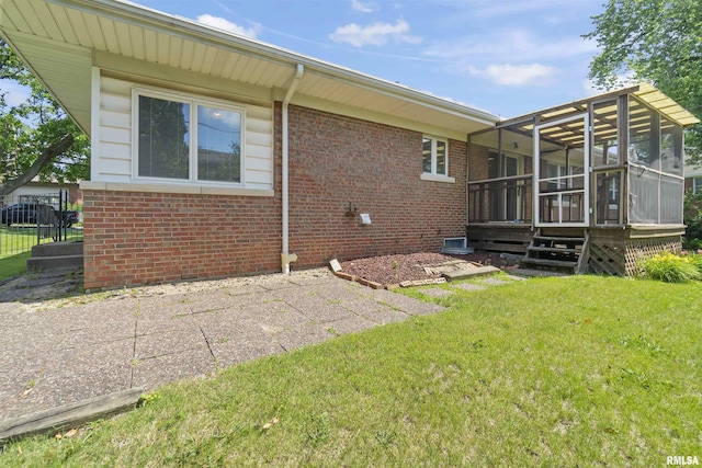 502 W Crestwood Dr, Peoria, IL 61614 - rear view of house featuring a sunroom, brick siding, a lawn, and a patio