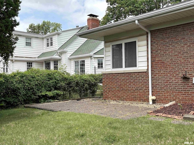 502 W Crestwood Dr, Peoria, IL 61614 - view of side of property with a chimney, brick siding, and a lawn