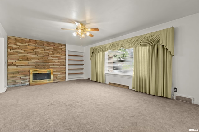 502 W Crestwood Dr, Peoria, IL 61614 - unfurnished living room with a ceiling fan, a stone fireplace, and carpet flooring
