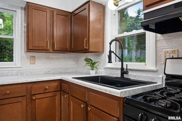 1431 E Rouse Ave, Peoria, IL 61614 - kitchen with range hood, decorative backsplash, range with gas cooktop, and brown cabinetry