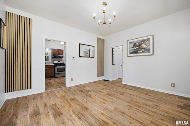 1431 E Rouse Ave, Peoria, IL 61614 - unfurnished room with light wood finished floors and a chandelier