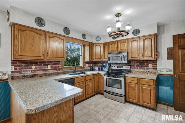 1522 N Stone School Rd, Elmwood, IL 61529 - kitchen featuring stainless steel appliances, brown cabinets, a peninsula, light countertops, and wallpapered walls