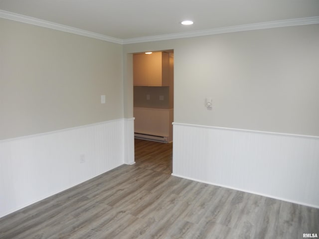 300 E Summer St, Plymouth, IL 62367 - spare room featuring baseboard heating, a wainscoted wall, wood finished floors, crown molding, and recessed lighting