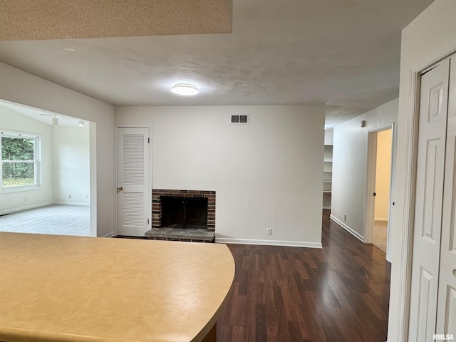 133 Holden Dr, Macomb, IL 61455 - unfurnished living room featuring dark wood-style floors and a fireplace