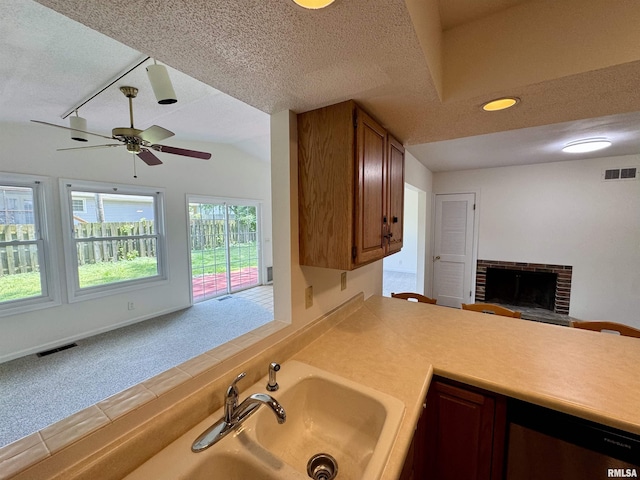 133 Holden Dr, Macomb, IL 61455 - kitchen with open floor plan, a textured ceiling, ceiling fan, light countertops, and brown cabinets