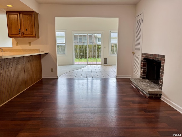133 Holden Dr, Macomb, IL 61455 - unfurnished living room with dark wood-type flooring and a brick fireplace