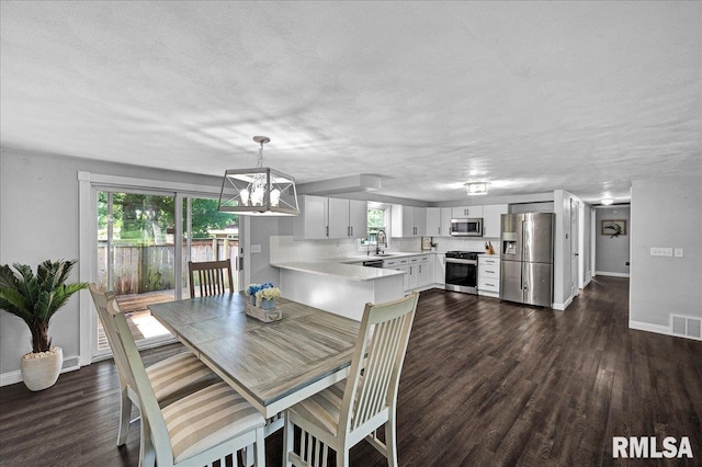 1536 Hickory Point Rd, Metamora, IL 61548 - dining area with dark wood-type flooring, a chandelier, and a textured ceiling