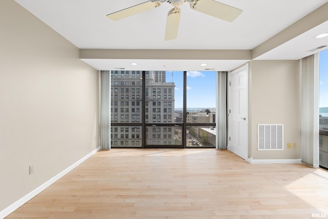 123 SW Jefferson St Unit E10C, Peoria, IL 61602 - empty room with expansive windows, plenty of natural light, wood finished floors, ceiling fan, and recessed lighting