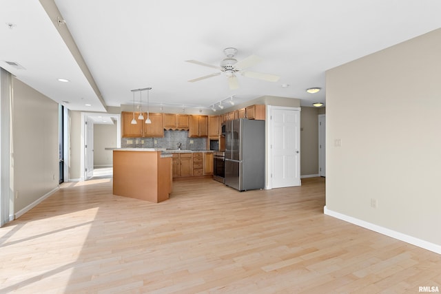 123 SW Jefferson St Unit E10C, Peoria, IL 61602 - kitchen featuring stainless steel appliances, light countertops, backsplash, light wood-style flooring, and a ceiling fan