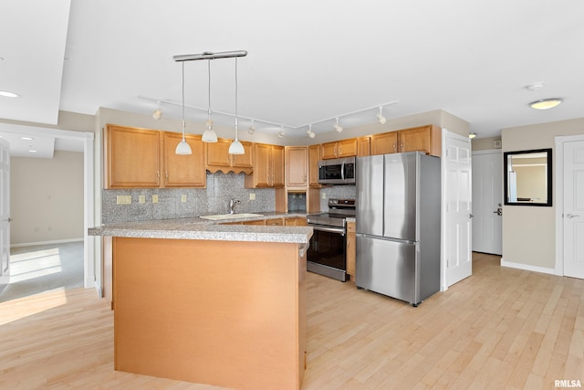 123 SW Jefferson St Unit E10C, Peoria, IL 61602 - kitchen featuring stainless steel appliances, light countertops, light wood-style floors, backsplash, and decorative light fixtures