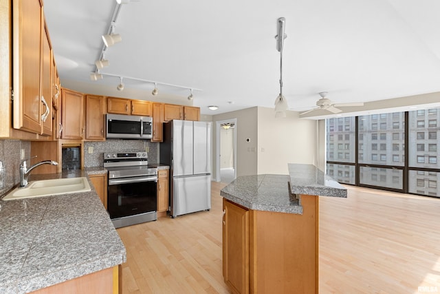 123 SW Jefferson St Unit E10C, Peoria, IL 61602 - kitchen with appliances with stainless steel finishes, tile countertops, light wood finished floors, a kitchen island, and a ceiling fan