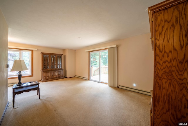 748 E Poplet Hollow Rd, Peoria, IL 61614 - unfurnished living room featuring a baseboard heating unit, healthy amount of natural light, and carpet floors