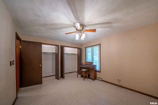 748 E Poplet Hollow Rd, Peoria, IL 61614 - bedroom featuring two closets, light colored carpet, a baseboard radiator, and ceiling fan