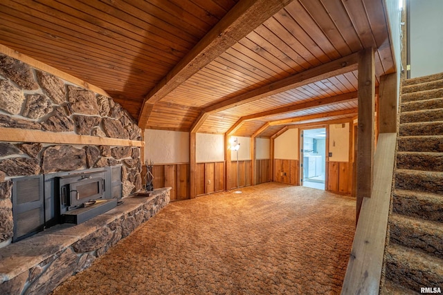 748 E Poplet Hollow Rd, Peoria, IL 61614 - unfurnished living room featuring a wood stove, a wood ceiling with exposed beams, stairs, wainscoting, and carpet flooring