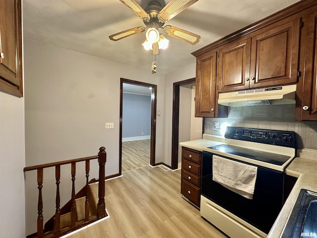 904 E Forrest Hill Ave, Peoria, IL 61603 - kitchen with under cabinet range hood, range with electric stovetop, light countertops, light wood finished floors, and ceiling fan