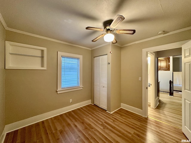 904 E Forrest Hill Ave, Peoria, IL 61603 - unfurnished bedroom with wood finished floors, a closet, crown molding, and a ceiling fan