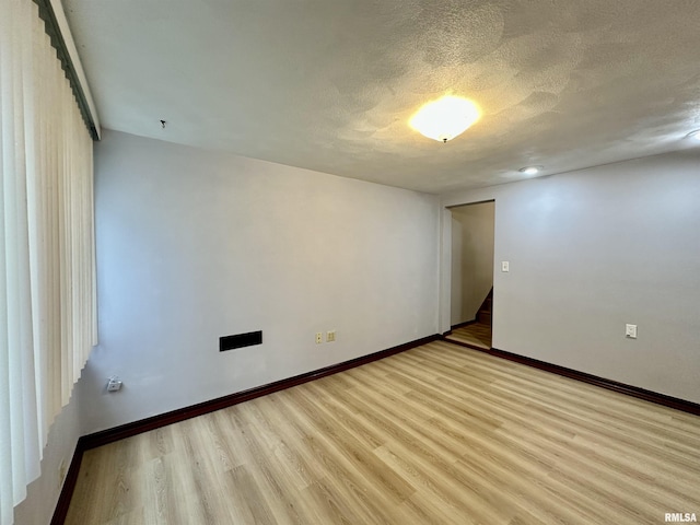 904 E Forrest Hill Ave, Peoria, IL 61603 - spare room featuring wood finished floors and a textured ceiling