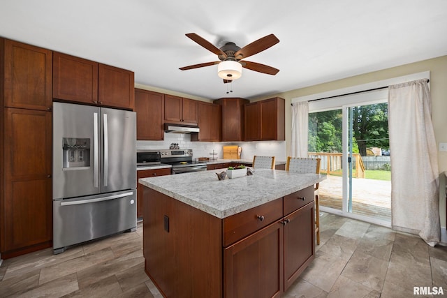 411 E 3rd St, Delavan, IL 61550 - kitchen featuring stainless steel appliances, under cabinet range hood, light countertops, tasteful backsplash, and a center island