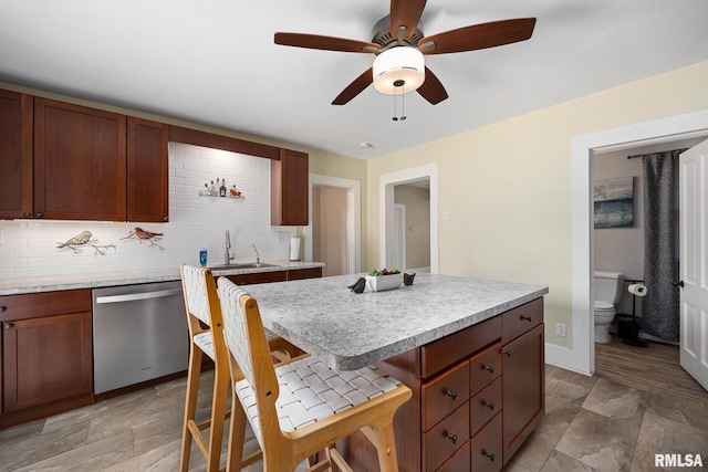411 E 3rd St, Delavan, IL 61550 - kitchen featuring stainless steel dishwasher, light countertops, a breakfast bar, and a ceiling fan