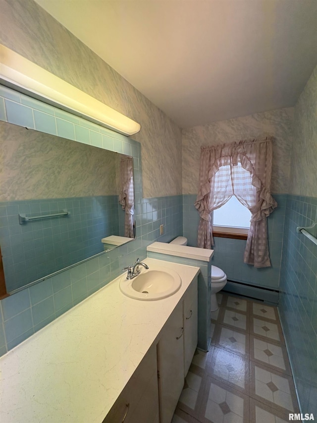 505 S Davenport St, Metamora, IL 61548 - bathroom with tile walls, a baseboard radiator, vanity, a wainscoted wall, and tile patterned floors