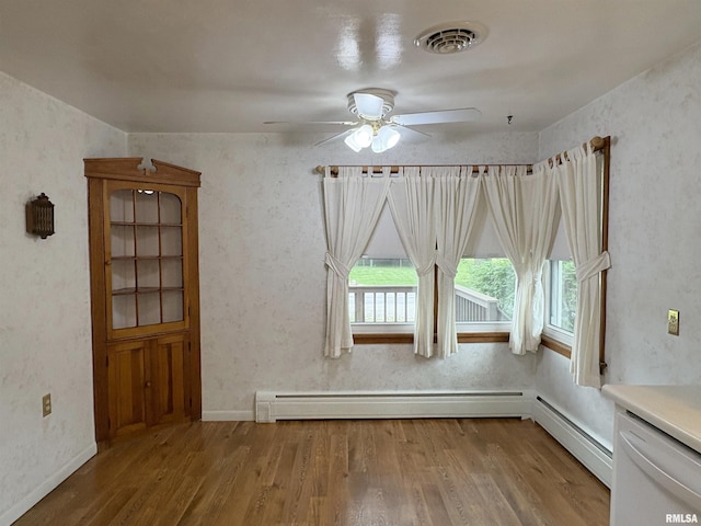 505 S Davenport St, Metamora, IL 61548 - unfurnished dining area with ceiling fan, wood finished floors, and baseboard heating