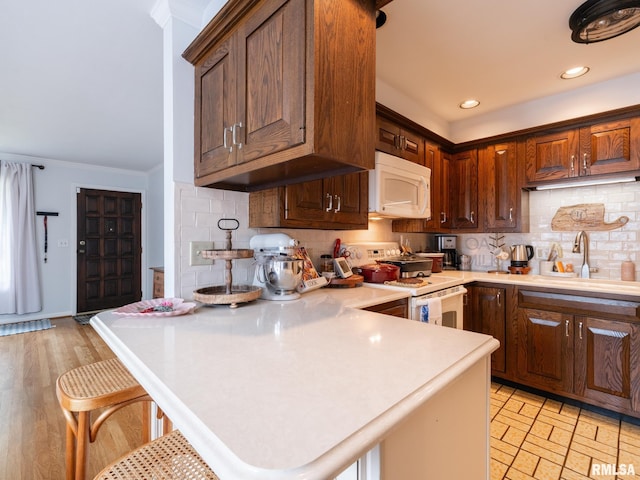 2705 N Victoria Ave, Peoria, IL 61604 - kitchen with white appliances, light countertops, backsplash, a kitchen breakfast bar, and ornamental molding