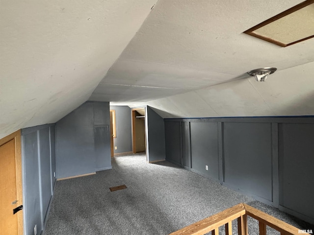 1210 W Macqueen Ave, Peoria, IL 61604 - additional living space with vaulted ceiling, carpet flooring, a textured ceiling, and a decorative wall