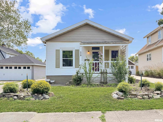 510 W Willcox Ave, Peoria, IL 61604 - view of front facade with covered porch, a front lawn, and a garage